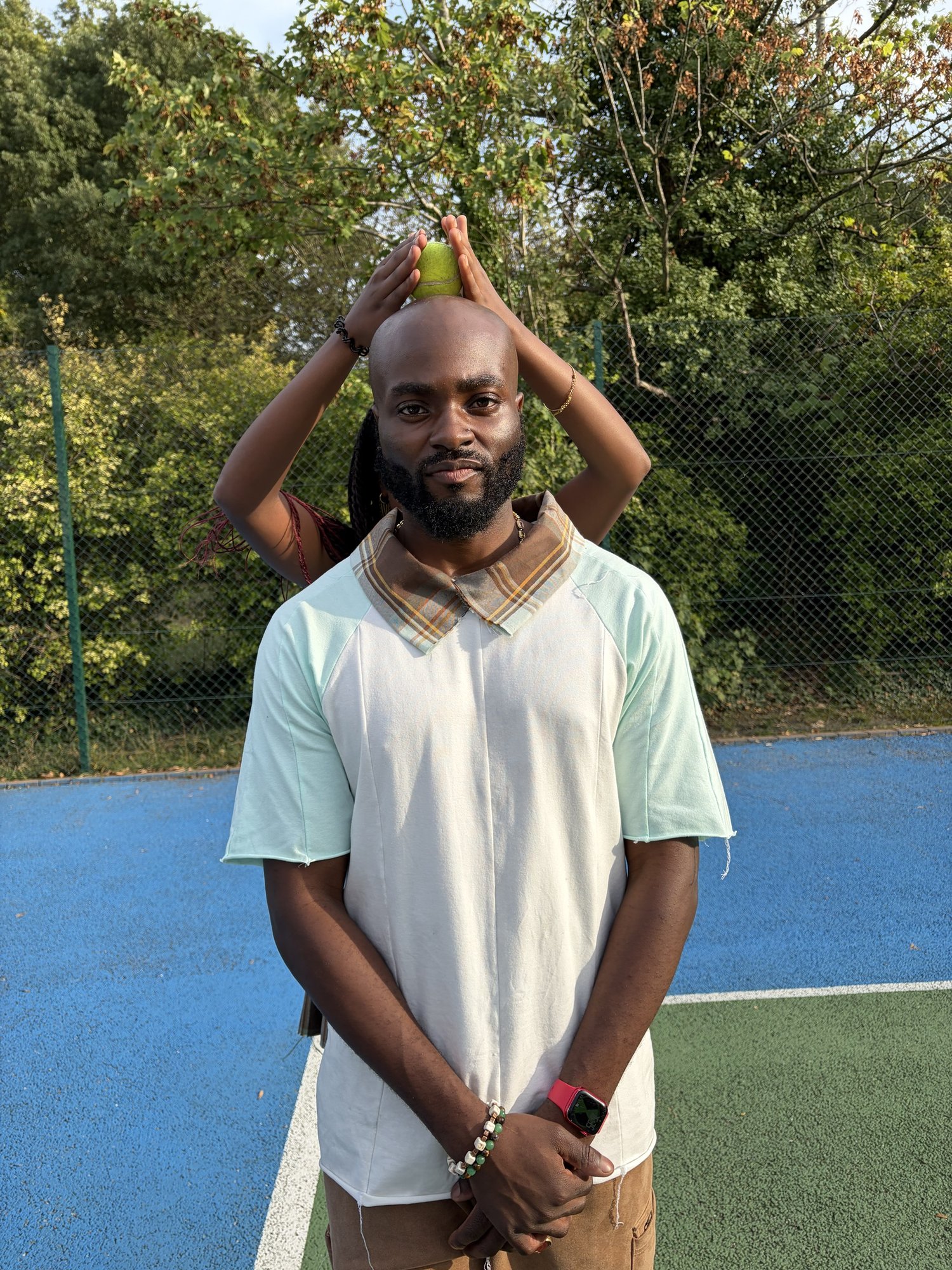 obi balancing a tennis ball on his head, Kah'Nya behind him