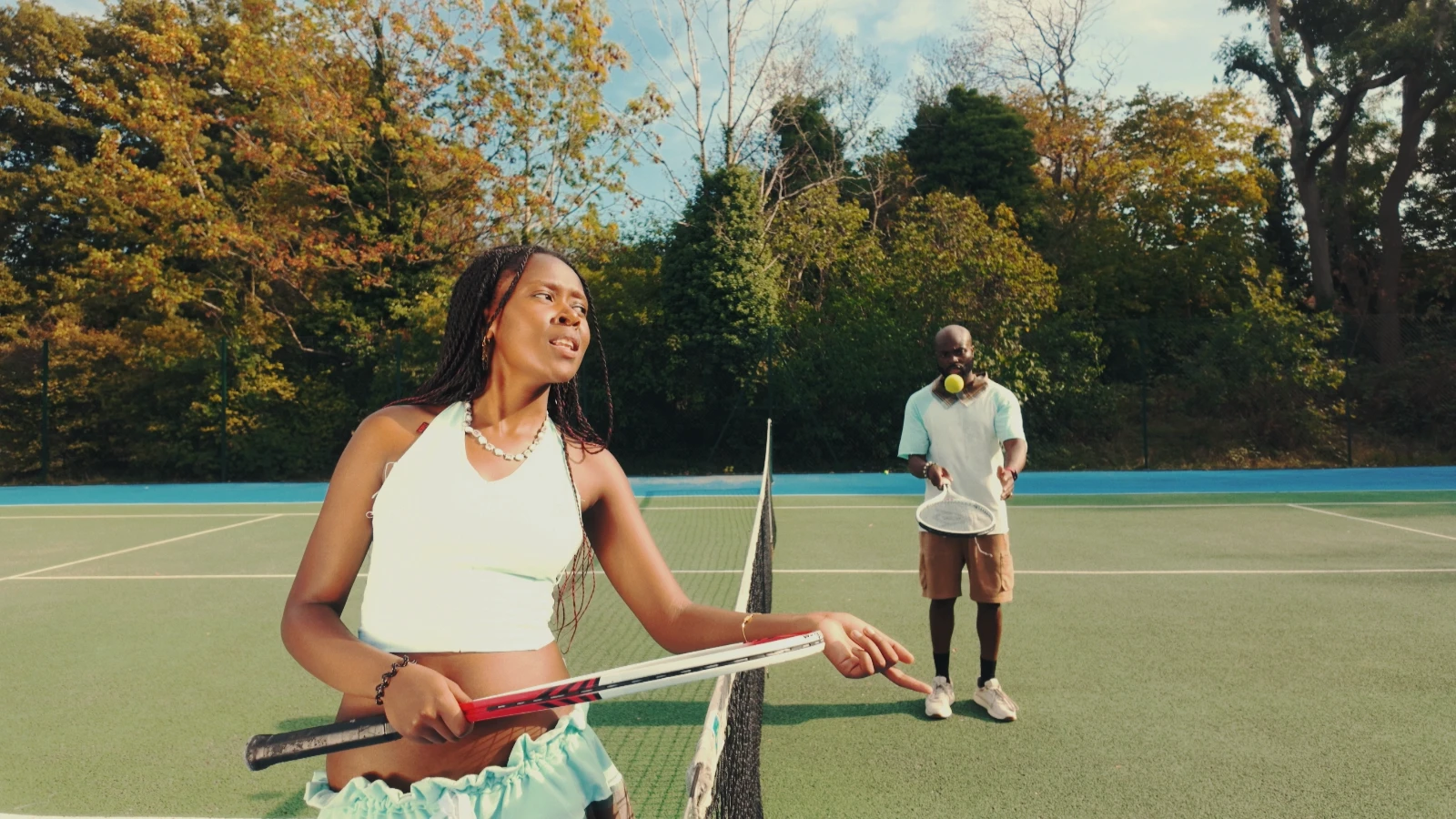 Kah'Nya at the net while obi tosses a tennis ball behind her