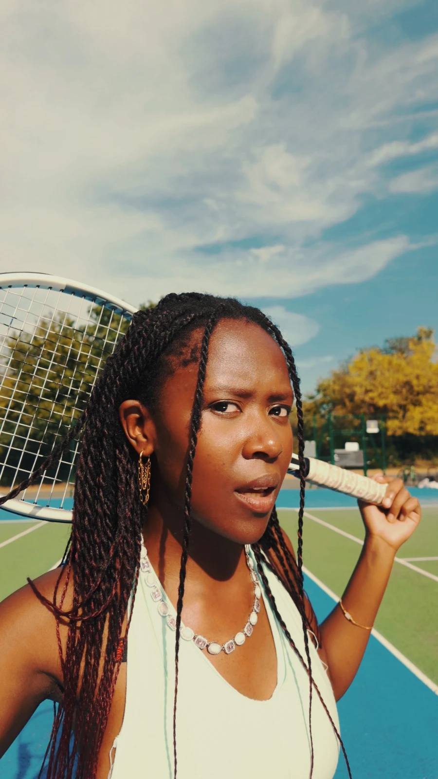 Kah'Nya with her racket over her shoulder, giving a sideways look