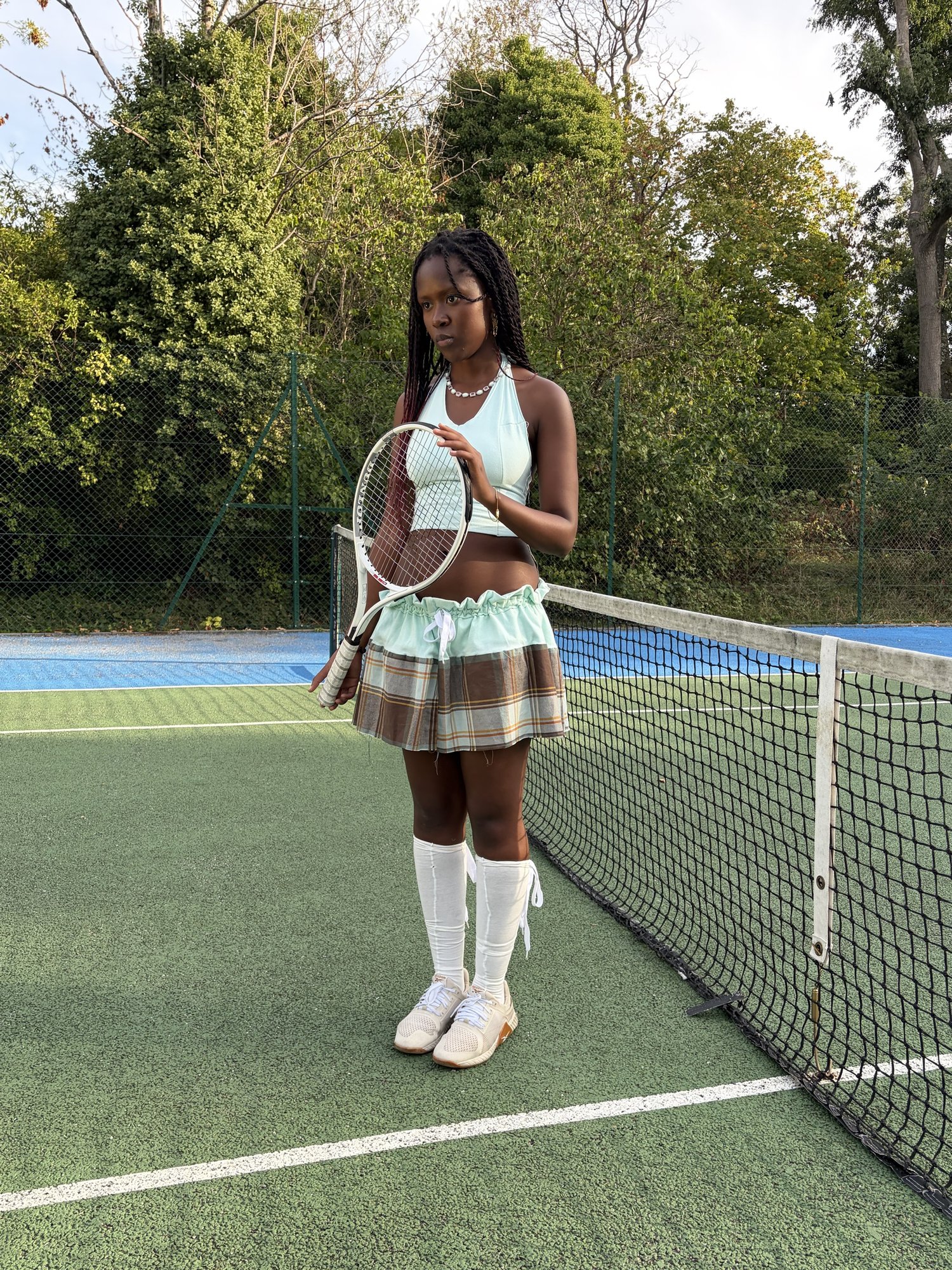 Kah'Nya holding a racket up, looking off camera
